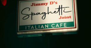 Illuminated sign of Jimmy D's Spaghetti Joint, an Italian cafe, captured at night.