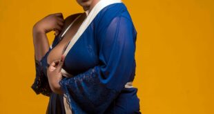 Confident African woman in blue attire posing against a vibrant yellow background.