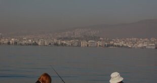 Two fishermen enjoying a peaceful day by the coast in İzmir, Turkey.