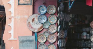 Vibrant handcrafted ceramic plates displayed at a Marrakesh market stall.