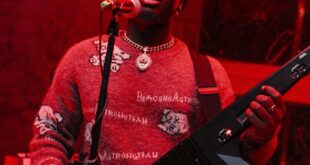 Musician performing with a keytar in a vibrant Accra venue. Live music atmosphere.