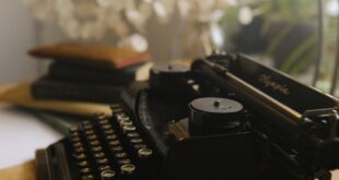 Close-up of a vintage typewriter in a cozy indoor setting with warm lighting.