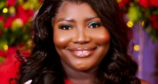 A radiant bride in a red dress smiling in a floral setting, showcasing beauty and happiness.