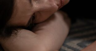 Close-up of a woman lying down, expressing sadness and crying.