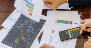 Business professionals analyzing financial charts and graphs during a meeting.