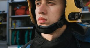 Portrait of a firefighter wearing a helmet in uniform, ready for action.