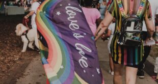 Vibrant pride parade featuring colorful outfits and pride flags, celebrating diversity and inclusion.