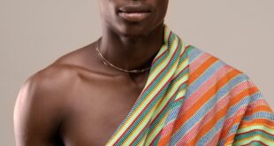 Portrait of a man wearing colorful Kente cloth, showcasing Ghanaian culture.
