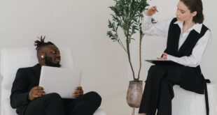 Diverse adults engaging in a productive business meeting with digital devices indoors.
