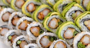 A close-up of assorted sushi rolls with vibrant veggies and seafood, freshly prepared and artfully arranged.