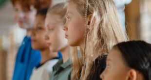 Children lined up in a school setting, showcasing diversity and focus during a classroom activity.