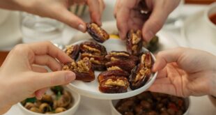 A group sharing dates and various dishes on a festive dining table, capturing warmth and togetherness.