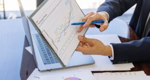 Business professionals discussing financial graphs and charts in an office setting.