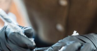 A tattoo artist concentrates as they work on a new design in a studio.