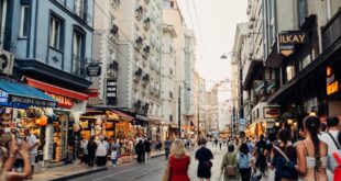 A lively day scene depicting people walking along a bustling street in Istanbul, Turkey.