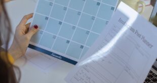 Businesswoman organizing social media strategy with content planners in a home office.