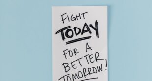 Handwritten motivational quote with American flags on blue surface.