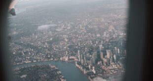 A captivating aerial view of a cityscape captured through an airplane window, showcasing the skyline and river.