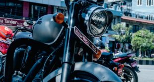 Close-up of a Royal Enfield motorcycle parked on a busy urban street.