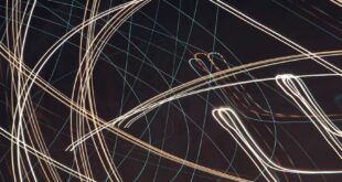 An abstract capture of vivid light streaks creating dynamic patterns against a dark background.