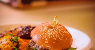 Tasty artisan burger served with scrumptious sides in a cozy setting.