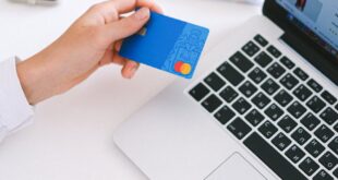 Person making an online purchase with a credit card on a laptop, showcasing modern ecommerce technology.