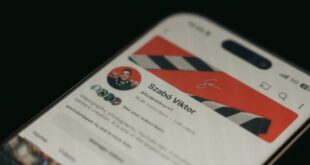 A smartphone showing a YouTube channel page screenshot in focus with blurred background.