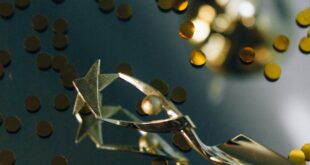 Stylish trophy atop shiny surface surrounded by gold confetti, symbolizing success.