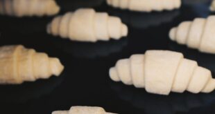 Uncooked croissants arranged on a baking tray, ready for the oven.