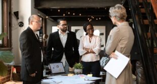 A group of professionals having a discussion in a contemporary loft office setting.