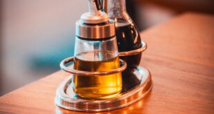 Elegant olive oil and vinegar set on a wooden restaurant table in Accra, Ghana.