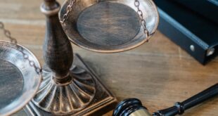 From above of judicial symbols consisting of Scales of Justice and small judge hammer with curly handle