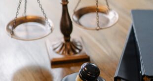 A striking image featuring a brass justice scale and gavel on a wooden desk, symbolizing law and justice.