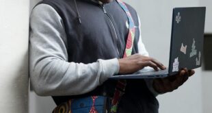Young man using laptop outdoors in Accra, Ghana. Engaged in technology and learning.