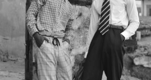 Black and white portrait of two men in vintage fashion with flat caps in Sekondi-Takoradi, Ghana.