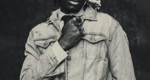 Black and white portrait of a man in denim jacket with flower in Ghana.