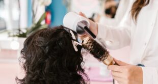 Woman receiving a hairstyle makeover in a vibrant salon setting.