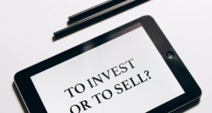 Tablet displaying 'To Invest or To Sell?' question, symbolizing investment decisions.
