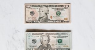 A neat flat lay of US dollar bills on a white marble surface, symbolizing finance and currency.