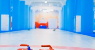 Vibrant indoor curling rink showcasing granite stones and broom.