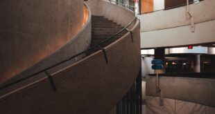 Elegant modern spiral staircase in a contemporary urban building interior.