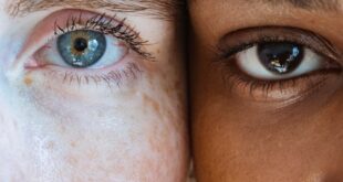 A close-up portrait showing a diverse pair of women with contrasting skin tones together.