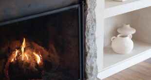 Warm and inviting fireplace with wooden mantel in a stylish living room setting, featuring modern decor.