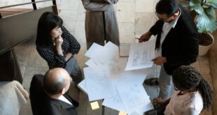 A team of professionals engage in a business meeting in a sleek, modern office setting.