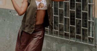 Fashionable woman posing against a building in Accra, Ghana, showcasing modern style.