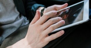 Close-up of hands using a tablet inside a car. Ideal for themes of technology and travel.
