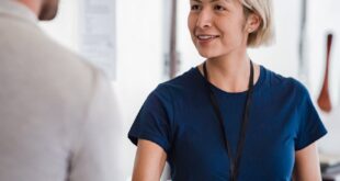 Friendly handshake between business professionals in an office environment, emphasizing teamwork.
