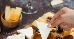 Assorted gourmet cheese platter with honey and white wine pairing.