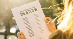 A woman reads a meetup schedule under the warm sunlight in a park in Istanbul.