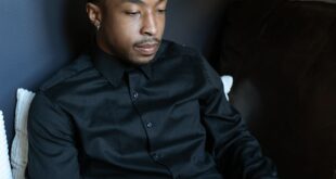 Man in black shirt using a laptop in a stylish indoor workspace.